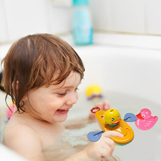 Enfant dans la baignoire joue avec le jouet de bain Canard en kayak