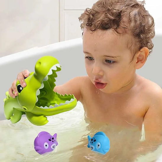 Petit garçon plonge un poisson dans la bouche du Mini Alligator Gourmand pendant le bain
