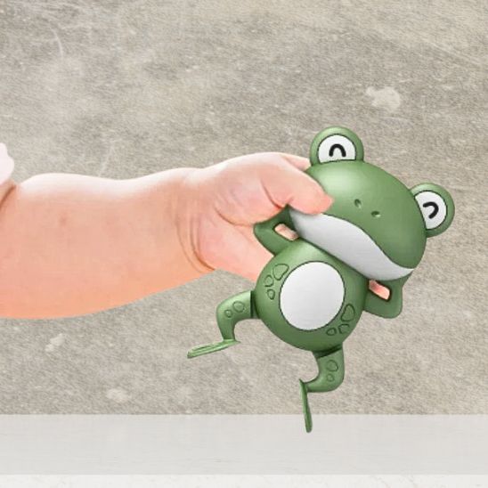 La main de bébé qui tient son jouet de bain