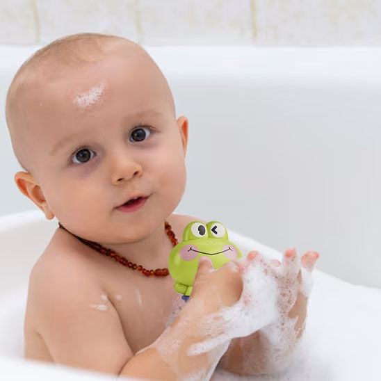 Bébé souriant joue avec son jouet de bain bébé coloré dans la mousse