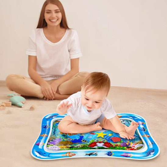Bébé joue sur son tapis d'eau d'éveil et sa maman à côté très contente