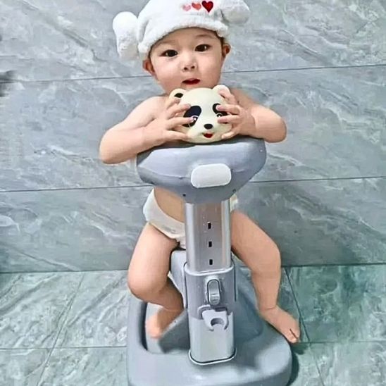 Un petit enfant assis bien installé dans sa baignoire bébé pour douche style PANDA