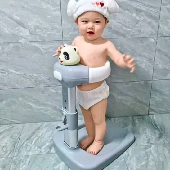 Un petit enfant assis bien installé debout en sécurité dans sa baignoire bébé pour douche style PANDA
