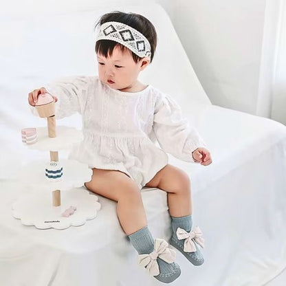 Bébé met dans ses pieds ces Chaussettes antidérapantes | Style coréen à nœud papillon de couleur bleu, entrain de jouer.