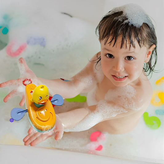 Enfant dans la baignoire joue avec le jouet de bain Canard en kayak.