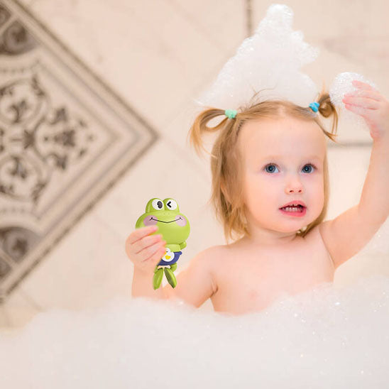 Petite fille s’amuse dans la baignoire avec son jouet de bain bébé coloré