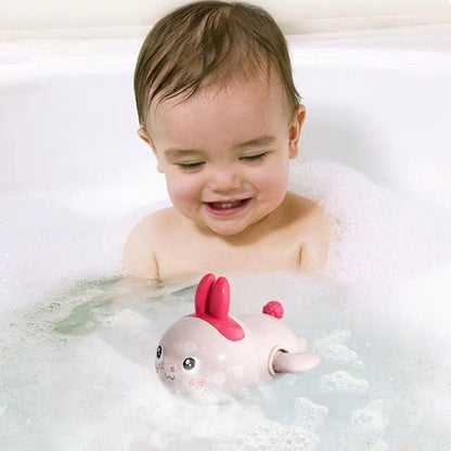 Bébé joue avec son jouet de bain lapin dans sa baignoire