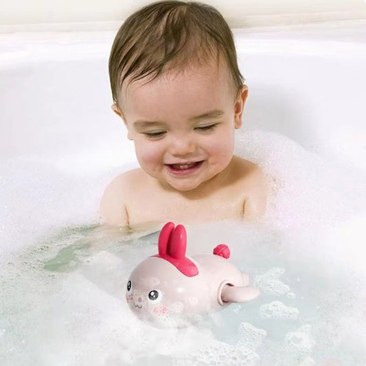 Bébé joue avec son jouet de bain lapin dans sa baignoire