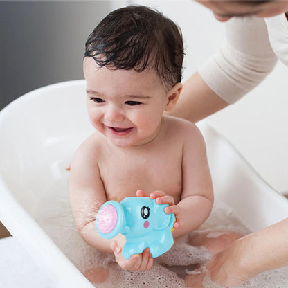 bébé souriant dans son bain joue avec son arrosoir éléphant sous le regard attendri de sa maman.