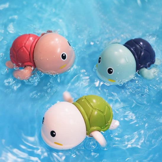 Trois tortues Totue nageant dans l’eau, jouet de bain bébé stimulant l’éveil aquatique.