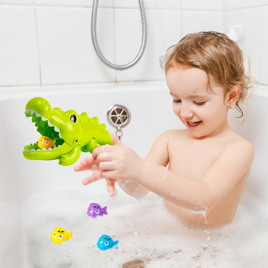 Petit enfant fasciné joue avec le crocodile qui a avalé un poisson colorés