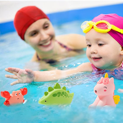 Fillette qui joue avec des jouets de bain animaux safari dans la piscine avec sa maman heureuse
