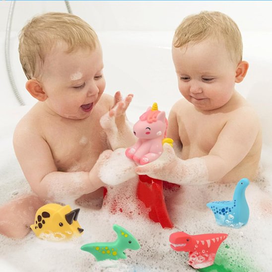Jumeaux dans la baignoire avec de la mousse jouant avec leurs jouets de bain