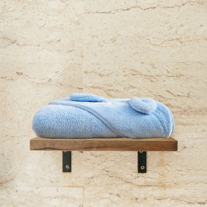 La cape de bain bébé bien pliée et ranger sur l'étagère de bain