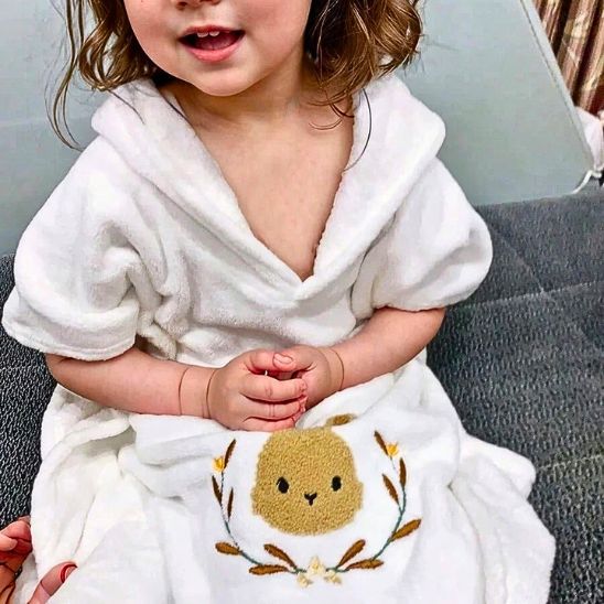 La fillette met sa cape de bain trop mignonne et confortable