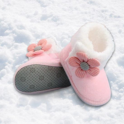 Gros plan sur des chaussures bebe avec pompons,rose, chaussures souples confortables pour nouveau-né et tout-petit.