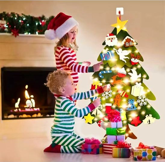 Bébé et sa sœur en train de décorer le sapin de Noël 