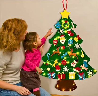 La petite avec sa maman en train de décorer le petit sapin en feutre