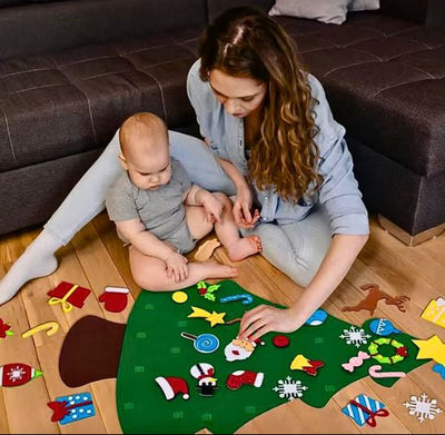 Bébé regarde attentivement sa maman qui l'éveille avec ces ornements à accrocher sur l'arbre de Noël