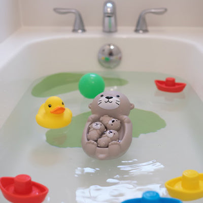Jeu sensoriel avec les loutres flottant dans la baignoire